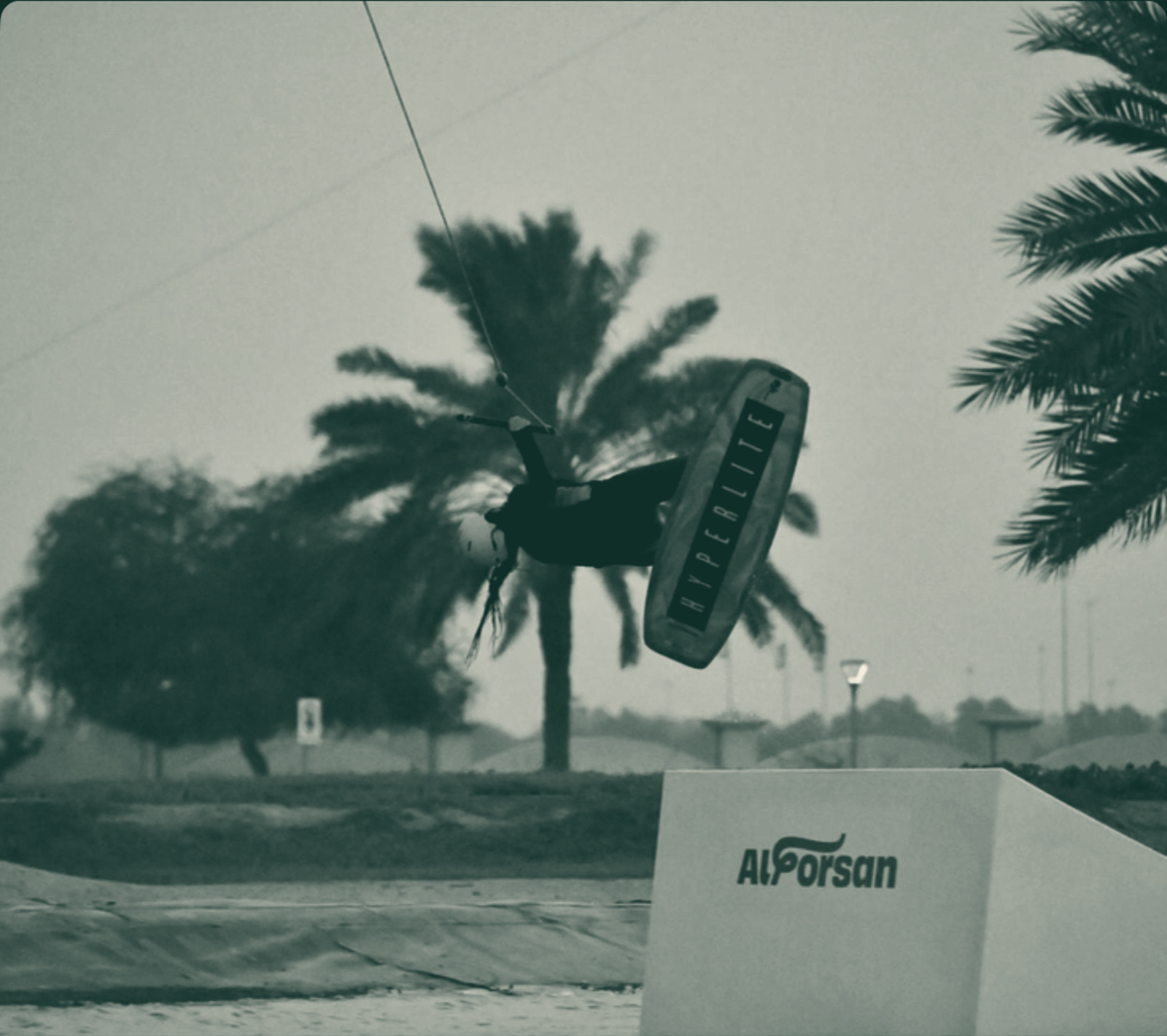 Me upside down above the kicker at Al Forsan cable park, board overhead